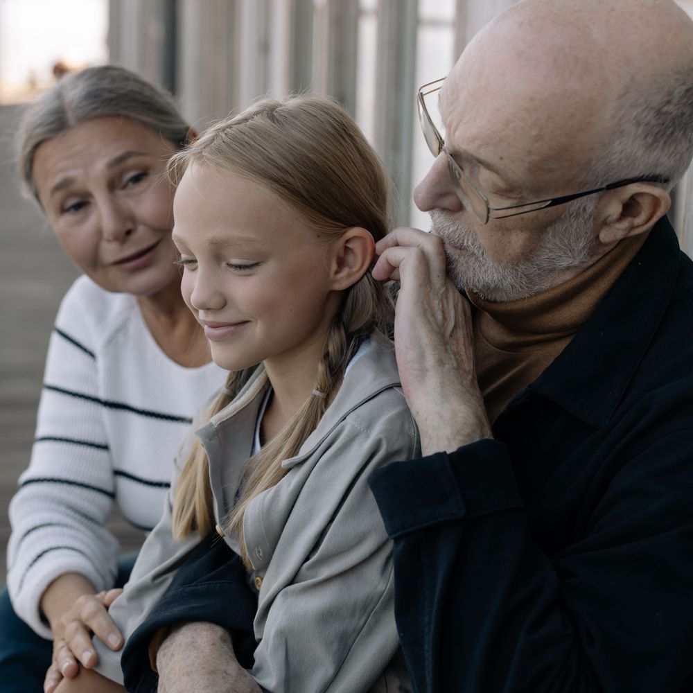 Des grands-parents assis avec leur petite-fille